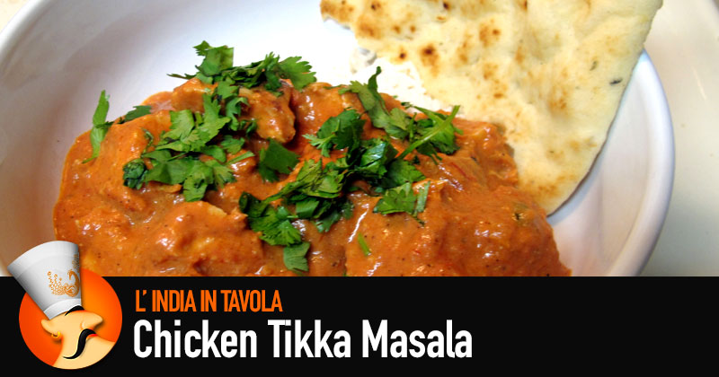 La ricetta del pollo tikka masala: carne ricoperta di salsa rossa, con foglie verdi di coriandolo e un naan